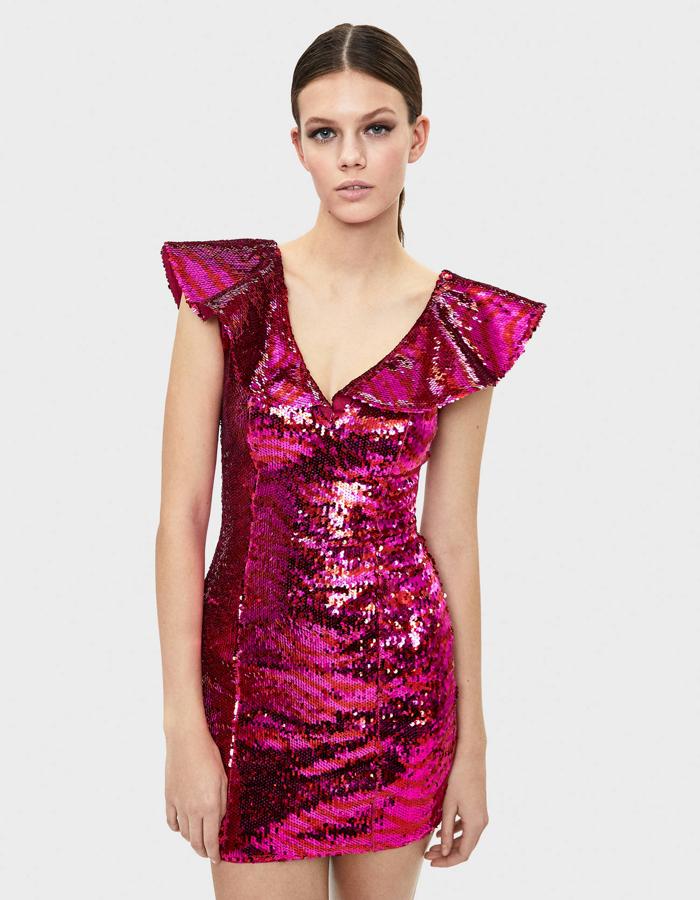 Si te decides por los brillos en color, este vestido te va a encantar. De lentejuelas, mini y ajustado, su punto fuerte (además de este tono fucsia tan llamativo) es el escote con volante en forma de V (45,99 euros).