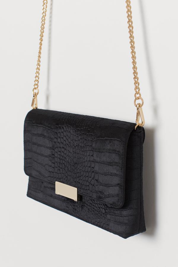 H&M apuesta por una de las versiones más clásicas del bolso de mano, con este clutch de velour con textura. Con un precio de 19,99 euros, además de la solapa tiene cremallera para acceder al interior.