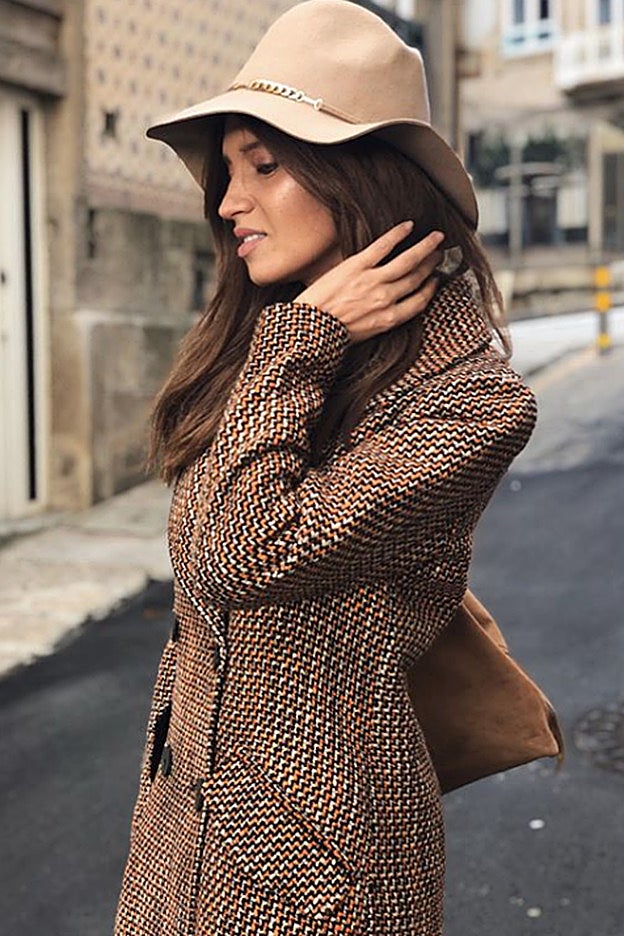 Sara Carbonero lleva el clásico abrigo de cuadros marrón que triunfa en la tendencia de temporada.