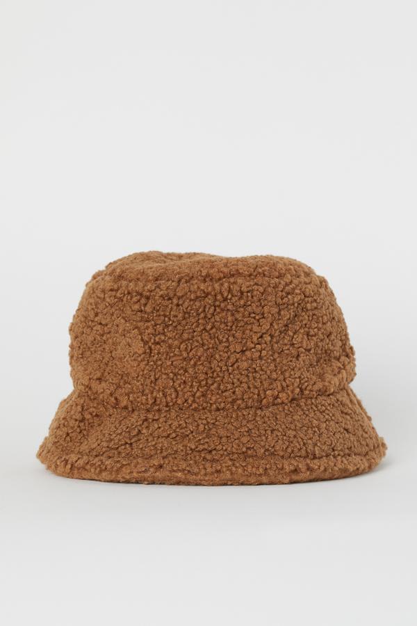 En H&M encontramos otro bucket adaptado a las tendencias otoñales, en esta ocasión en formato borreguillo. Cuesta 17,99 euros y también está disponible en blanco.