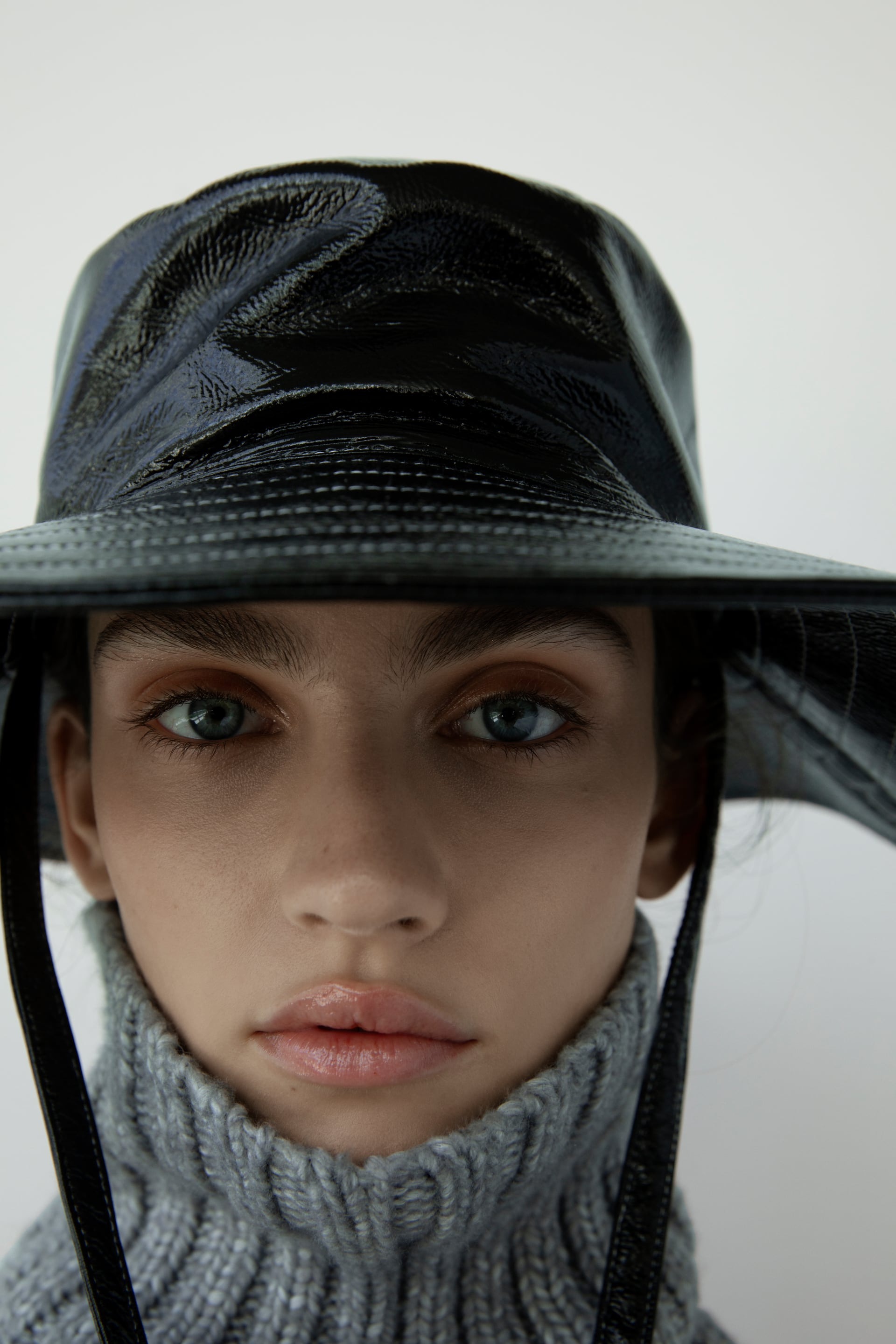 Por 17,95 euros en Zara podemos encontrar este bucket de ala ancha con pespuntes en charol negro. Con cintas para fijarlo al cuello, es una opción muy elegante y algo más favorecedora que la versión corta.