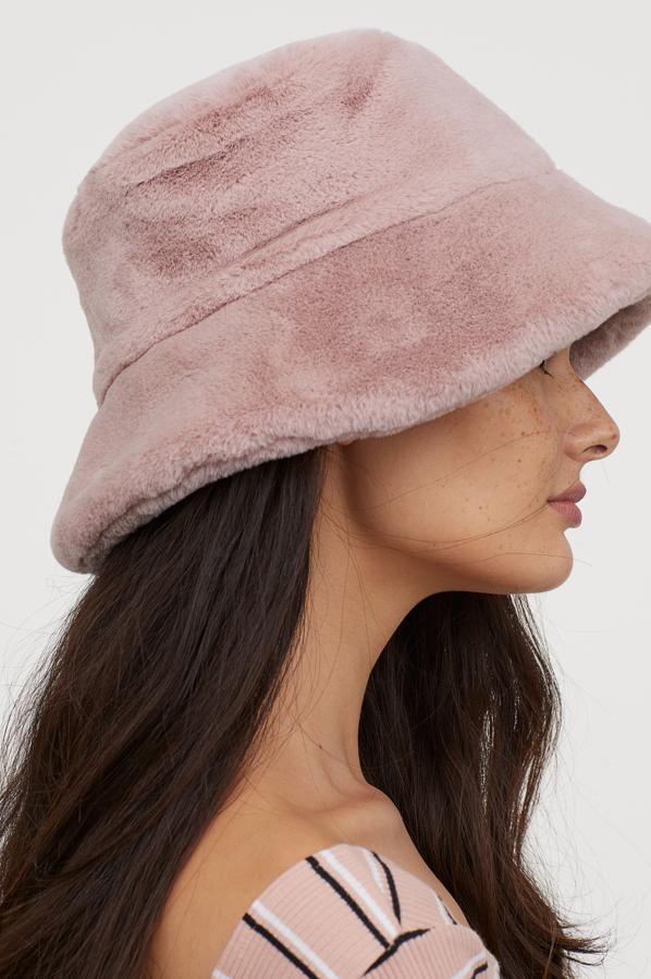 Con ala de doble capa y forro guateado ligeramente acolchado nos encontramos este bucket de pelo sintético extrasuave en rosa empolvado. También está disponible en negro y cuesta 14,99 euros.