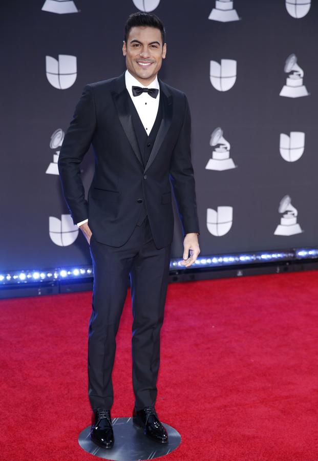 Carlos Rivera con traje negro, chaleco del mismo tono, camisa blanca y pajarita.