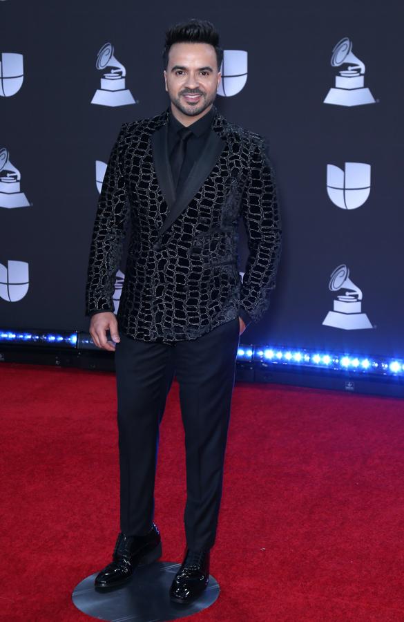 Luis Fonsi con un traje negro y chaqueta con hilo metalizado.