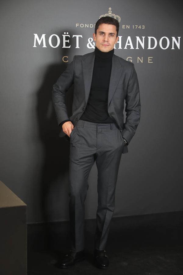 Álex González con un traje gris que combinó con un jersey de cuello alto negro.