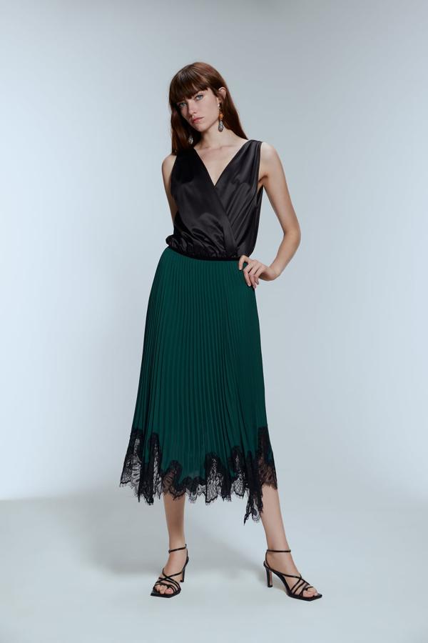 Con bajo asimétrico con aplicación de encaje combinada a contraste, esta falda de terciopelo en color verde botella es una de nuestras favoritas. La adaptación es de Zara y cuesta 39,95 euros.