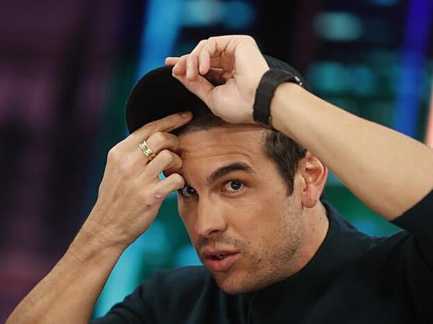 Mario Casas solo le enseñaba un poco, sin quitarse la gorra, el desastre capilar que le han hecho para caracterizarle en la película de Netflix que protagoniza.