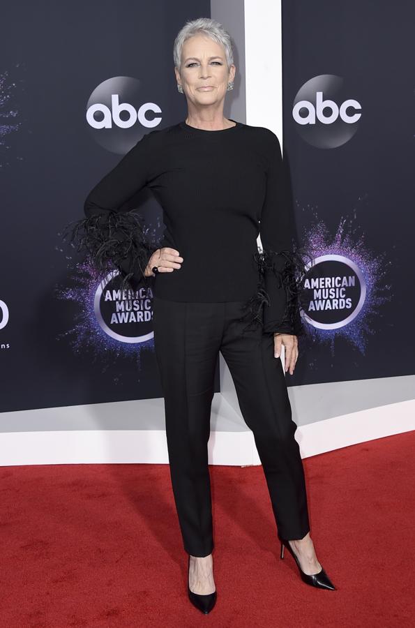Jamie Lee Curtis conun conjunto negro con cuerpo con mangas adornadas con plumas.