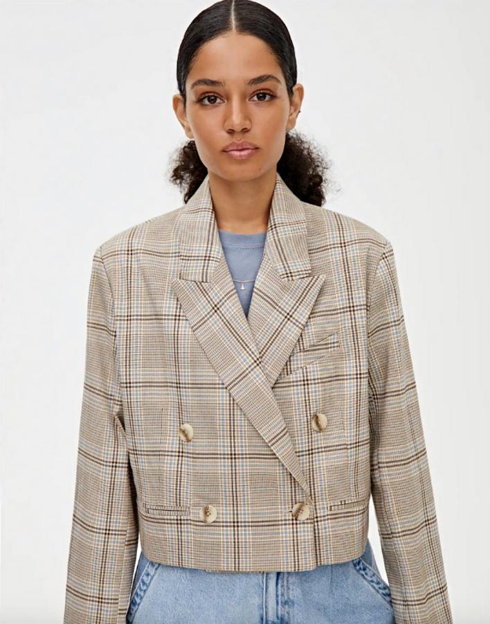 En tonos crudos con cuadros en tonos azules y botones nacarados, esta blazer corta es de Pull&Bear y tiene un precio de 25,99 euros.