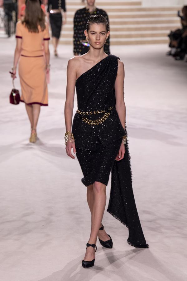 Este vestidazo con escote asimétrico y detalle capa que demuestra que el tweed también es un digno tejido de fiesta.