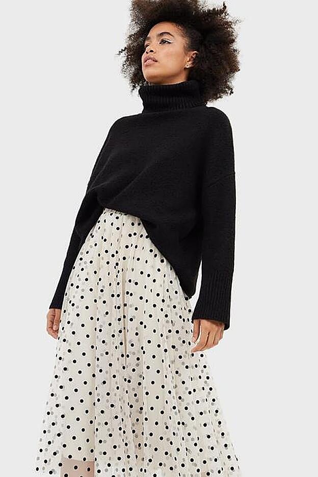 Trasparente, con forro blanco y lunares negros, la falda de Stradivarius.