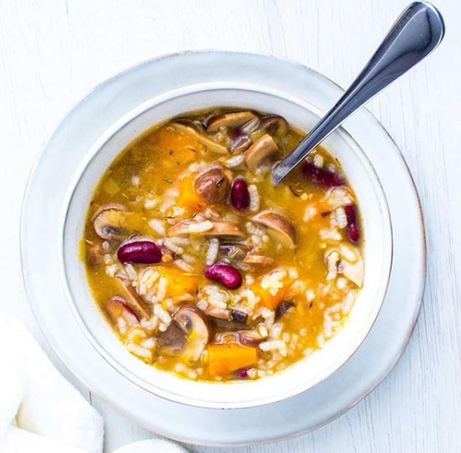 ngredientes:-150 gr de calabaza-130 gr de champiñones-100 gr de arroz redondo-100 gr de alubias rojas-50 gr de puerro-800 ml de agua-1 diente de ajo-1 tomate pera-Tomillo-Pimienta negra molida-Sal-AOVEPreparación:En una olla con un chorro de aceite, rehogar a fuego medio el ajo y el puerro (parte blanca) previamente picados evitando que se quemen.Incorporar los champiñones troceados y saltear junto con el puerro y el ajo hasta que se doren.Añadir la calabaza cortada en dados, el arroz y la pulpa rallada del tomate (descartar la piel). Remover bien para que el ácido del tomate recupere los sabores concentrados del fondo de la olla.Incorporar el agua, el tomillo, la sal y la pimienta. Cocer a fuego medio aprox. 15 min desde que rompe a hervir. En los últimos 5 min añadir las alubias rojas cocidas.