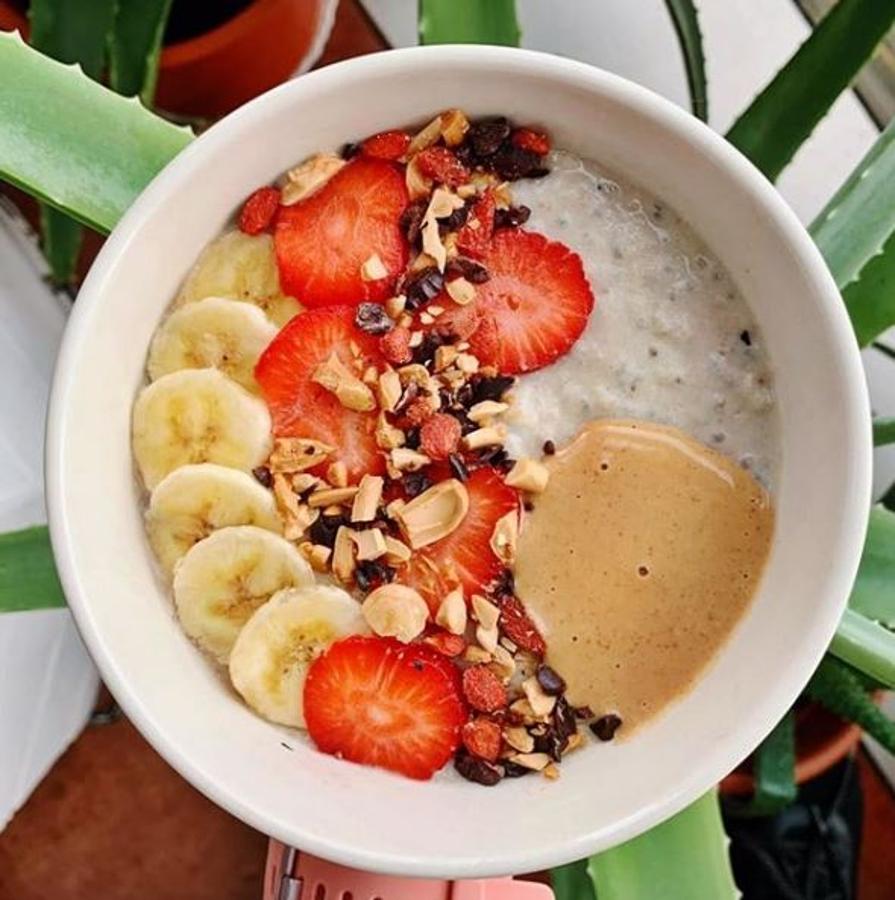 Ingredientes:-30 gr de copos de avena-1 cdta semillas de chia-1 plátano-1 cda harina de coco-3/4 de bloque de tofu silken-Canela-Maca-Bebida de cocoPreparación:Primero ponemos a hervir los copos de avena y chia con poquita agua. Mientras van espesando, batimos todos los demás ingredientes y los añadimos al cazo.Dejamos que se haga todo junto y vaya cogiendo algo de espesor. Al echarle el batido quedará una textura súper cremosa y además añadiremos un extra de proteína y de sabor.Decoramos con los toppings al gusto: plátano, fresas, almendras, nibs de cacao, bayas de goji y salsa de cacahuete y café (1 cdita de cacahuete en polvo + 1 cdita de crema de cacahuete y con un poco de café).