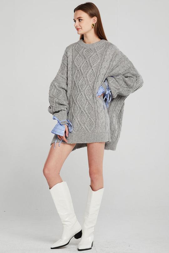 Hazte con uno oversize para utilizarlo como minivestido. Este gris de Storets combina los puños con una camisa de rayas azul. (77,95 euros).