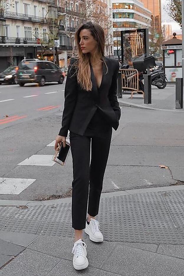 Teresa Bass con un traje negro y zapatillas blancas.