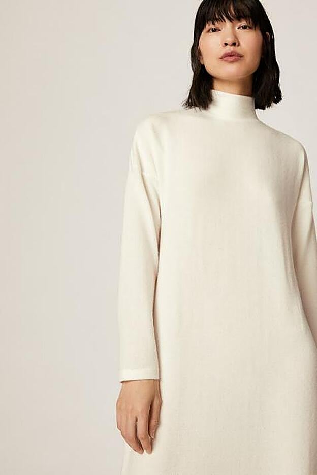 El vestido blanco tiene aberturas laterales en los bajos.