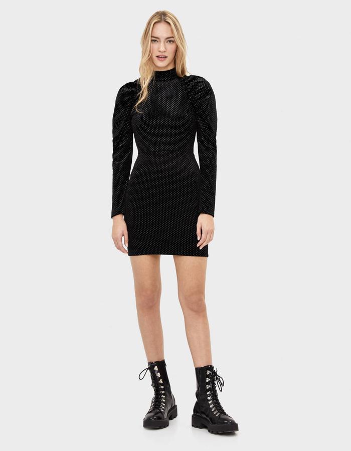 Minivestido ajustado de terciopelo negro con detalles 'brilli brilli' y mangas con volumen de Bershka (25.99 euros).