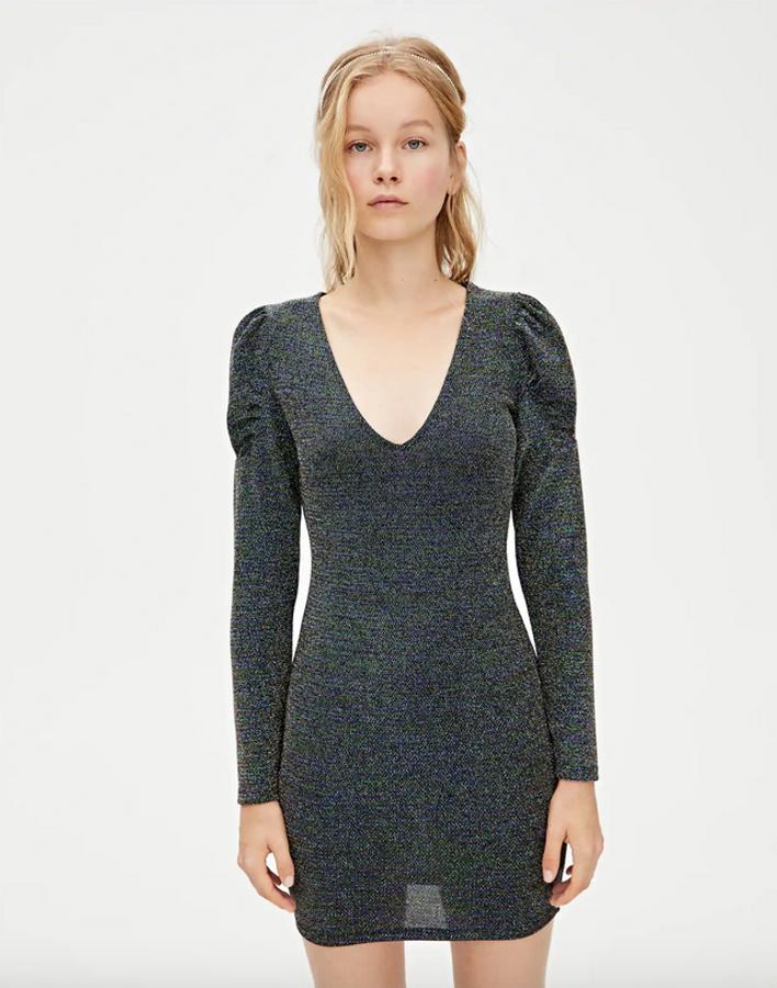 Si quieres ir sobre seguro, este vestido corto ajustado de Pull&Bear viene en un tejido brillante ideal para la Nochevieja. Con mangas abullonadas que lo introducen en las tendencias de la temporada, y un acertado escote de pico, este vestido cuesta 22,99 euros.