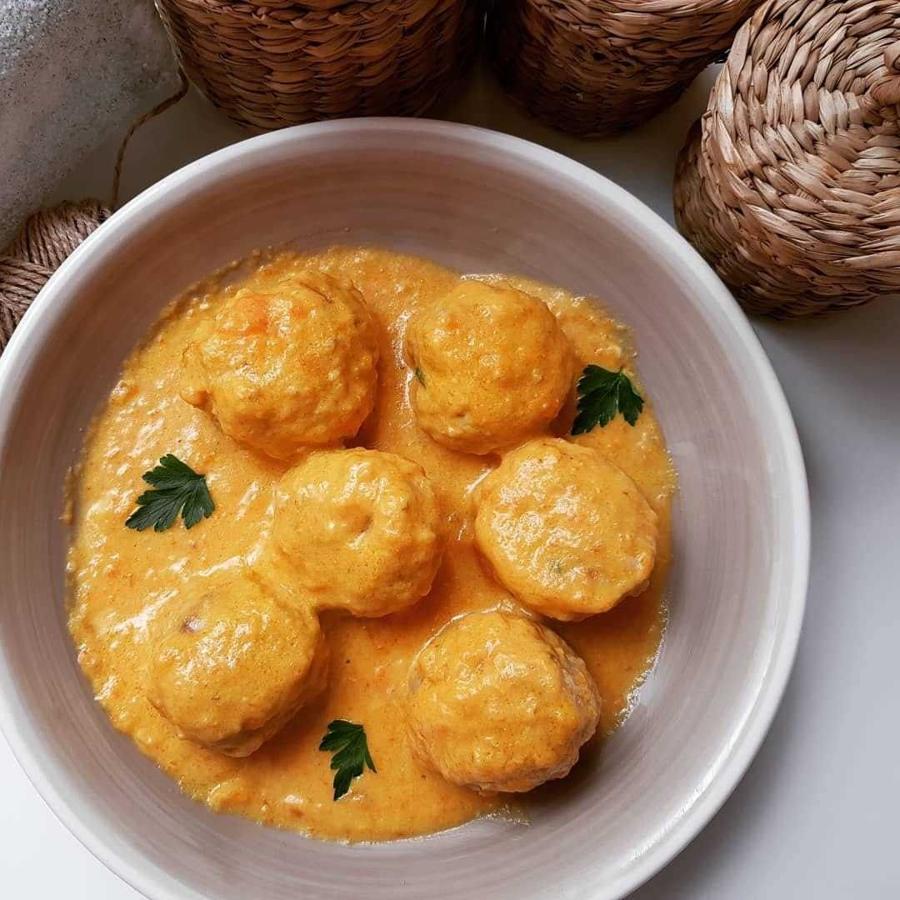 Ingredientes:500 gr de carne de cerdo y pollo1/2 cebolla1 huevoHarina integralYogur griego1 zanahoriaPimienta blancaPerejil frescoAOVESalCaldo vegetalPreparación:- Para las albóndigas, poner en un bol la carne triturada, 1 huevo, sal, 1/2 cebolla rallada, perejil fresco y pimienta blanca en polvo.- Dar forma redondeada y pasar por harina integral.- En una sartén antiadherente añadir un chorrito de AOVE y sellarlas. Reservar.- Para la salsa: En una sartén antiadherente añadir un chorrito de AOVE y sofreír 1/2 cebolla y 1 zanahoria rallada. Añadir caldo casero vegetal hecho con calabaza, tomate y cebolla. Dejar cocinar. Cuando esté listo, añadir 1 yogur griego, sal y batir.- Incorporar las albóndigas a la salsa y cocinar por ambos lados hasta que se hagan por dentro. Dejar reposar.