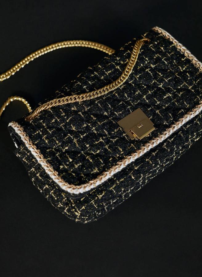 Bolso bandolera confeccionado en tejido de tweed, con cierre metálico y asa de cadena en tonalidad dorada. Está rebajado de 129 euros a 69,95 euros.