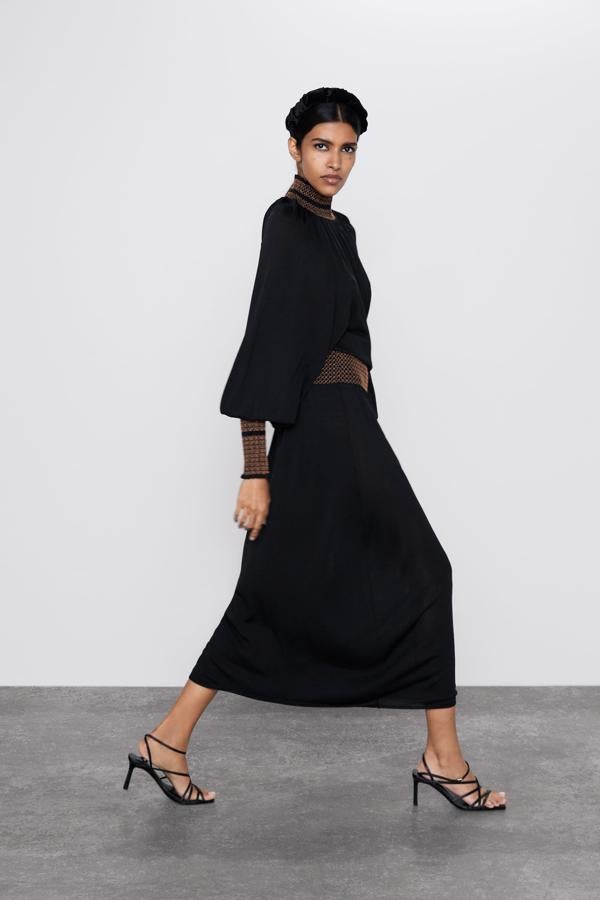 Un vestido midi negro con un toque dorado que le hace sumar muchos puntos en nuestra lista de deseos de las rebajas de invierno de Zara. Pasa de de 29.95 a 19.99 euros.