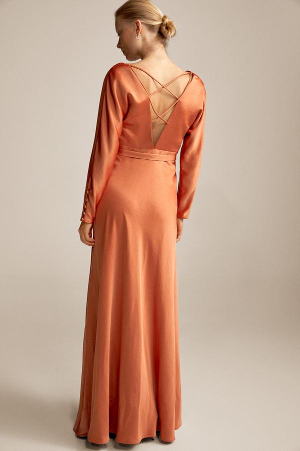 El naranja se ha ido colando poco a poco en nuestro armario, y no nos extraña al ver vestidos tan ideales como este de satén con original espalda de Pedro del Hierro, que en rebajas pasa de 349 a 139 euros.