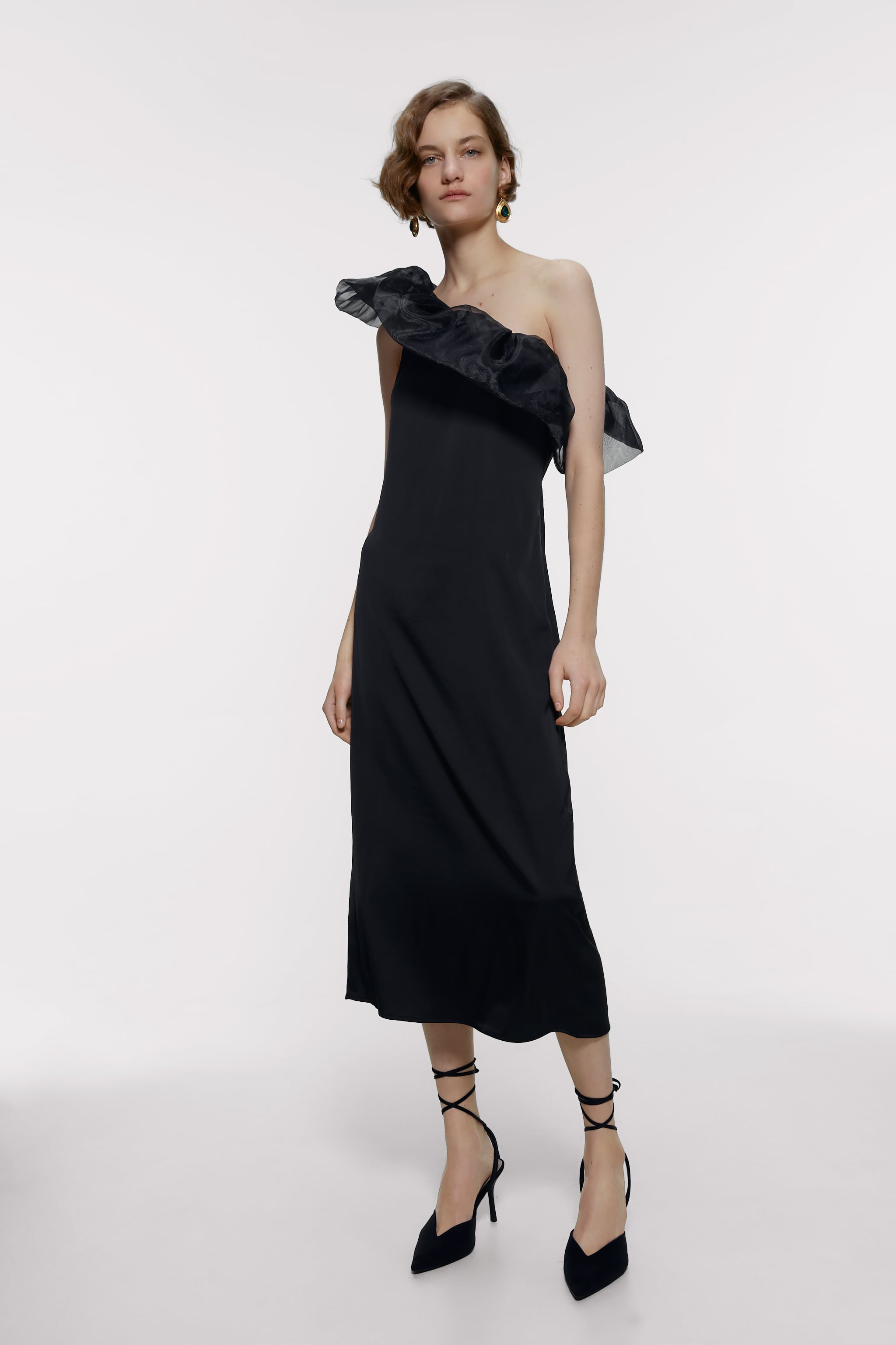También en negro, también elegantísimo y súper favorecedor, este vestido midi con escote asimétrico rematado en organza de  las rebajas de Zara  pasa de 29.95 euros a ¡19.99 euros!
