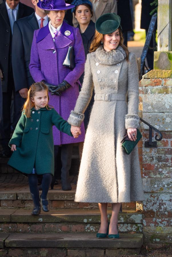 Solo unos días antes, y en el mismo escenario, Kate Middleton acudió a la Misa de Navidad con  este abrigo de lana color arena , con un favorecedor cinturón marcando el talle y rematado en piel en los puños y el cuello. También está firmado por Catherine Walker y la Duquesa de Sussex lo ha superpuesto a un vestido de Michel Kors en verde botella que combinaba a las mil maravillas (además de con el abriguito de la pequeña Charlotte) con sus zapatos y clutch de terciopelo a juego de Emmy London y un tocado de inspiración retro de Lock&Co.