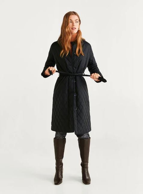 Trench largo de Mango con tejido nylon acolchado, cuello de solapa, cierre de botones y cinturón ajustable. Antes: 79,99 euros. Ahora: 49,99 euros.