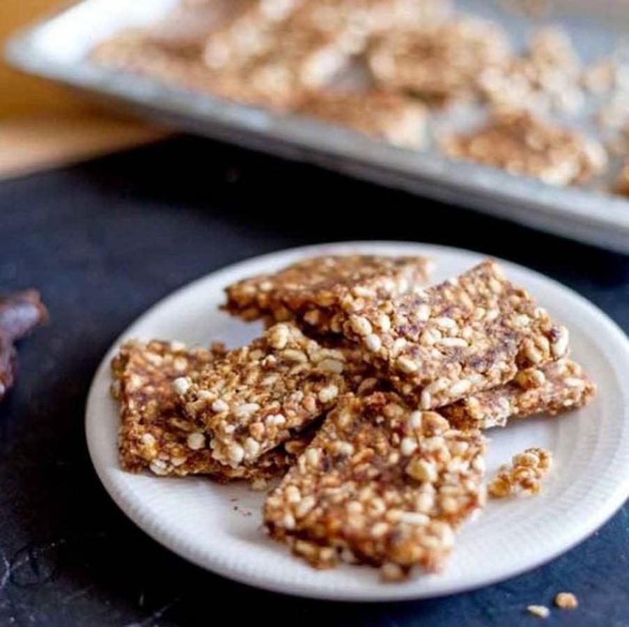 Ingredientes: -15 dátiles medjoul sin hueso remojados previamente-100 g de mantequilla de cacahuete sin azúcar-30 ml de agua del remojo de los dátiles-65 g de arroz inflado-65 g de copos de avena integral.-40 g de cacahuetes tostados -40 g de aceite de coco-30 g de semillas de lino trituradas-Canela molida al gusto-Una pizca de salPreparación:- Vamos a empezar por mezclar los alimentos secos: En un procesador tritura el cacahuate tostado con el lino hasta que te queden trozos pequeños. Reserva en un cuenco. Añade el arroz y los copos de avena, la canela y la sal.- Ahora mezclamos los alimentos húmedos: En el procesador tritura los dátiles con el agua hasta que te quede una mezcla suave y homogénea. (¡No te pases de agua!) Añade la crema de cacahuate, el aceite de coco, mezcla hasta que te quede todo bien integrado. - Toca el turno de juntar todo. Vierte la mezcla húmeda a la mezcla seca e integra bien con una espátula. Colócala en un molde previamente engrasado, alisa la superficie y reserva en la nevera al menos 2 horas. - Desmolda y corta en porciones a tu gusto.-Estas barritas energéticas son ideales para los niños, como pre-entreno y post-entreno y por qué no, por qué sí. Ojo no te pases con el agua de los dátiles porque luego te quedan muy húmedos y el efecto “crunch” desaparece. Si eres alérgico a los cacahuates siempre puedes hacerlas de almendra.