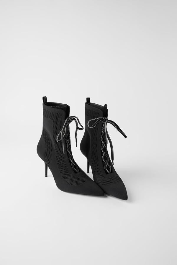 Botín de tacón fino y punta triangular de tejido elástico con cordones en la parte delantera. Rebajados de 49,95 euros a 25,99 euros.