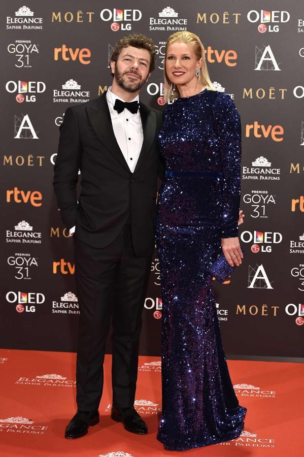 Anne Igartiburu, de Lorenzo Caprile, atiende a TVE mientras su marido, Pablo Heras-Casado, de Scalpers, la observa en la alfombra roja.