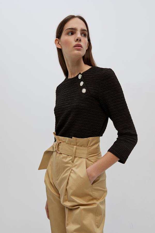 Tres botones con acabado perla son todo lo que necesita este cuerpo en manga tres cuartos y color negro de Sfera para convertirse en una prenda a tener en cuenta. Tiene un precio de 19,99 euros y está disponible entre las tallas S y XL.