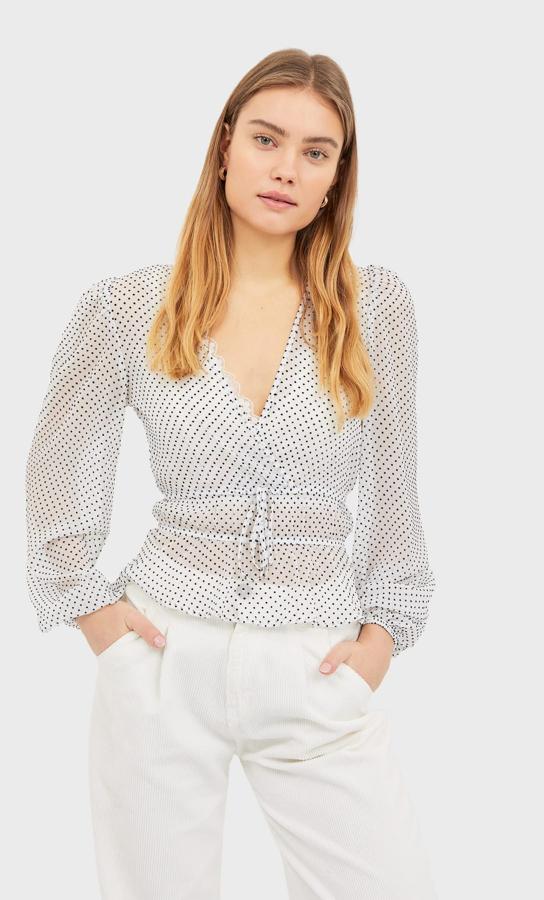 Blusa blanca semitransparente con estampado de lunares de la nueva colección de Stradivarius (15.99 euros).