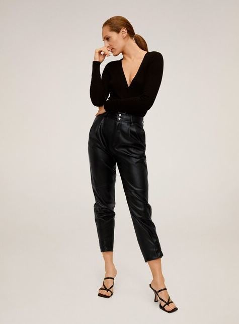 Los pantalones efecto piel se siguen manteniendo como una de las prendas más irresistibles en el armario de las que más saben de moda y el low cost los tiene en todas las versiones. Estos con pinzas y tiro alto de Mango son ideales y cuestan 35,99 euros.