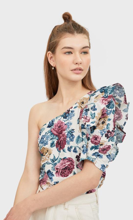 Con un hombro al descubierto y flores, es una opción muy romántica para llevar con vaqueros blancos. De Stradivarius, (17,99 euros).