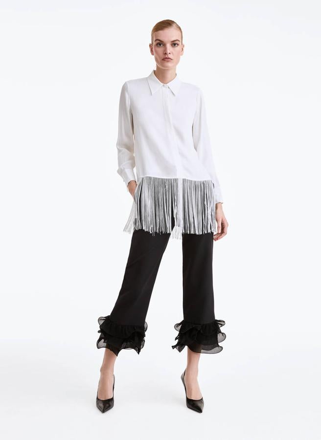 ¿Estás buscando un pantalón negro diferente? Este con volantes en el bajo es ideal para llevar con bailarinas. De Uterqüe, (89 euros).