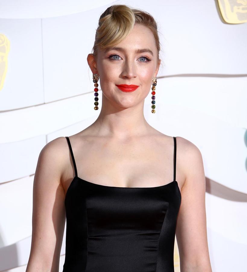 Saoirse ha arriesgado con su peinado, un recogido cuyo final se retuerce en la zona de la frente a modo de flequillo. Contrasta con su maquillaje clásico, a base de labios rojos, sombras rosadas y microeyeliner negro.