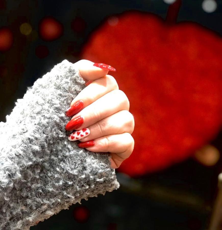 Un look de uñas para San Valentín bastante discreto es este, que cede el protagonismo del amor a una única uña, con corazones sobre fondo blanco, mientras que el resto lucen un ardiente rojo.