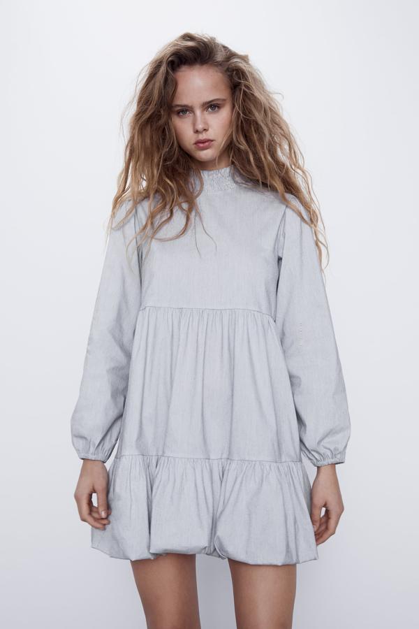 Vestido de cuello subido y manga larga acabados en elástico. Bajo acabado con volumen.