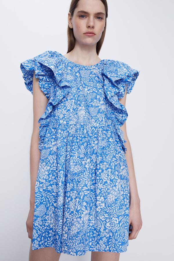 Vestido corto de cuello redondo y manga sisa. Detalle de volantes y pliegues. Cierre en espalda con abertura y botón.