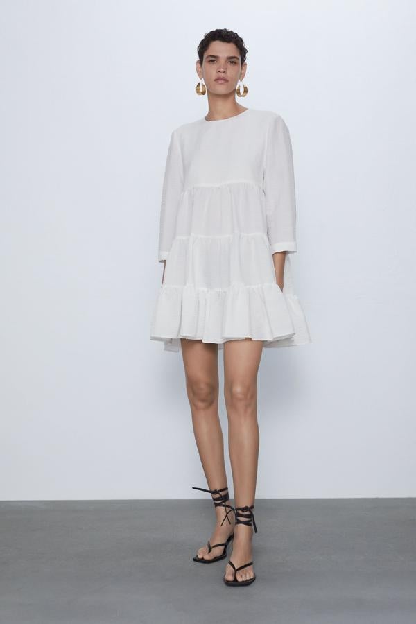 Vestido de cuello redondo y manga por debajo del codo. Detalle de volantes. Cierre en espalda con abertura y botón.