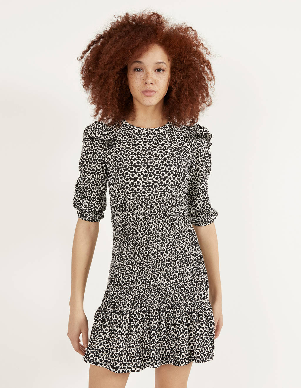 Elige los tonos blanco y negro como base para combinar el vestido de flores de la forma más fácil. Encuentra este de manga corta y volantes en Bershka por 19,99 euros.
