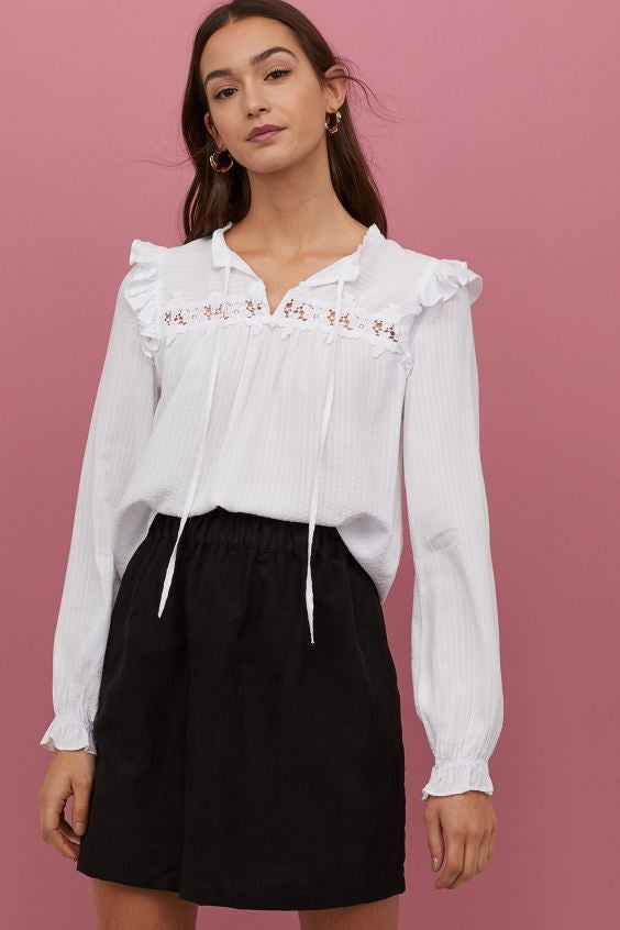 Blusa fluida con lazada en el escote, volantes y encaje. De H&M. (24,99 euros).
