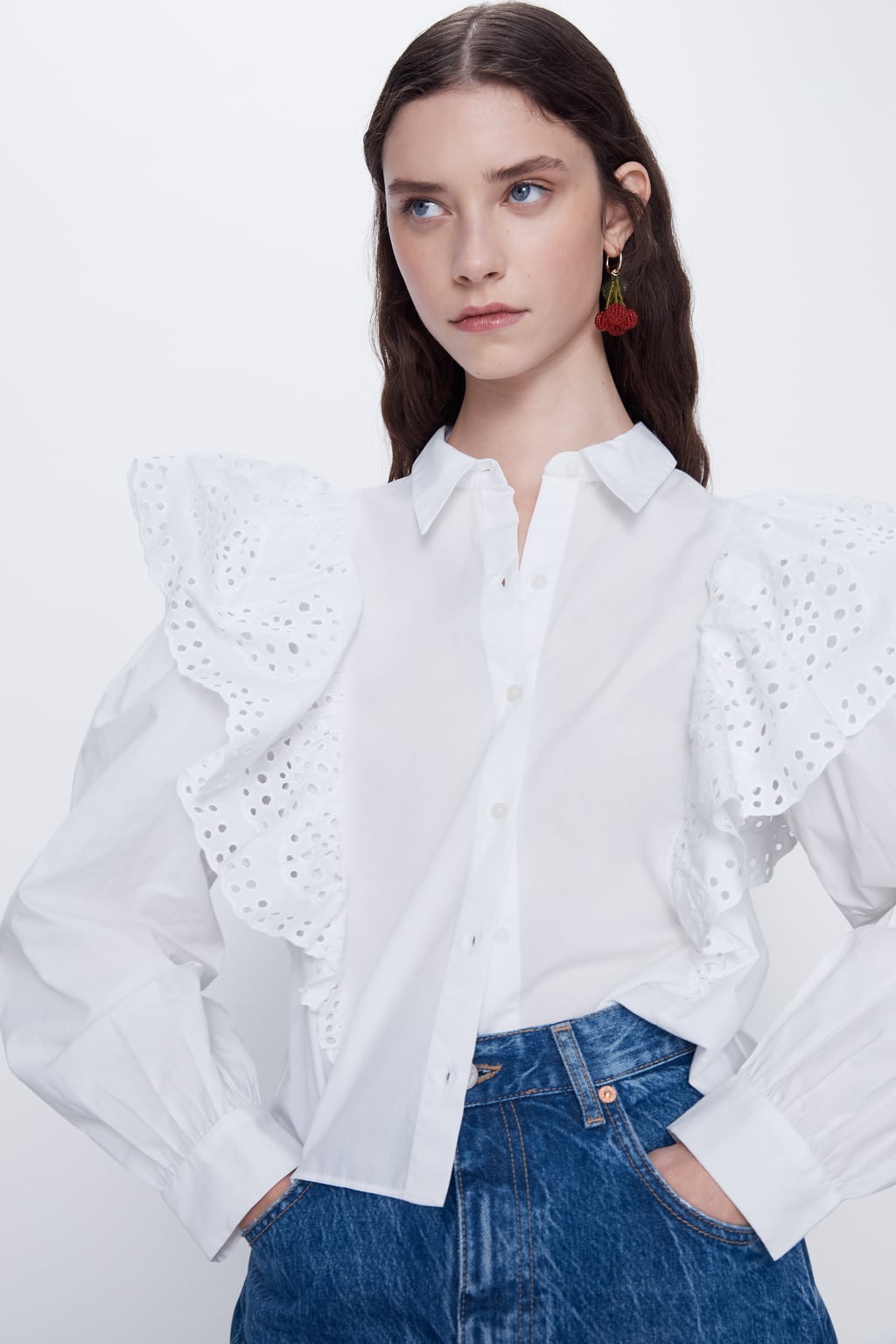 Camisa popelín en tono blanco con volantes calados. En Zara. (25,95 euros).