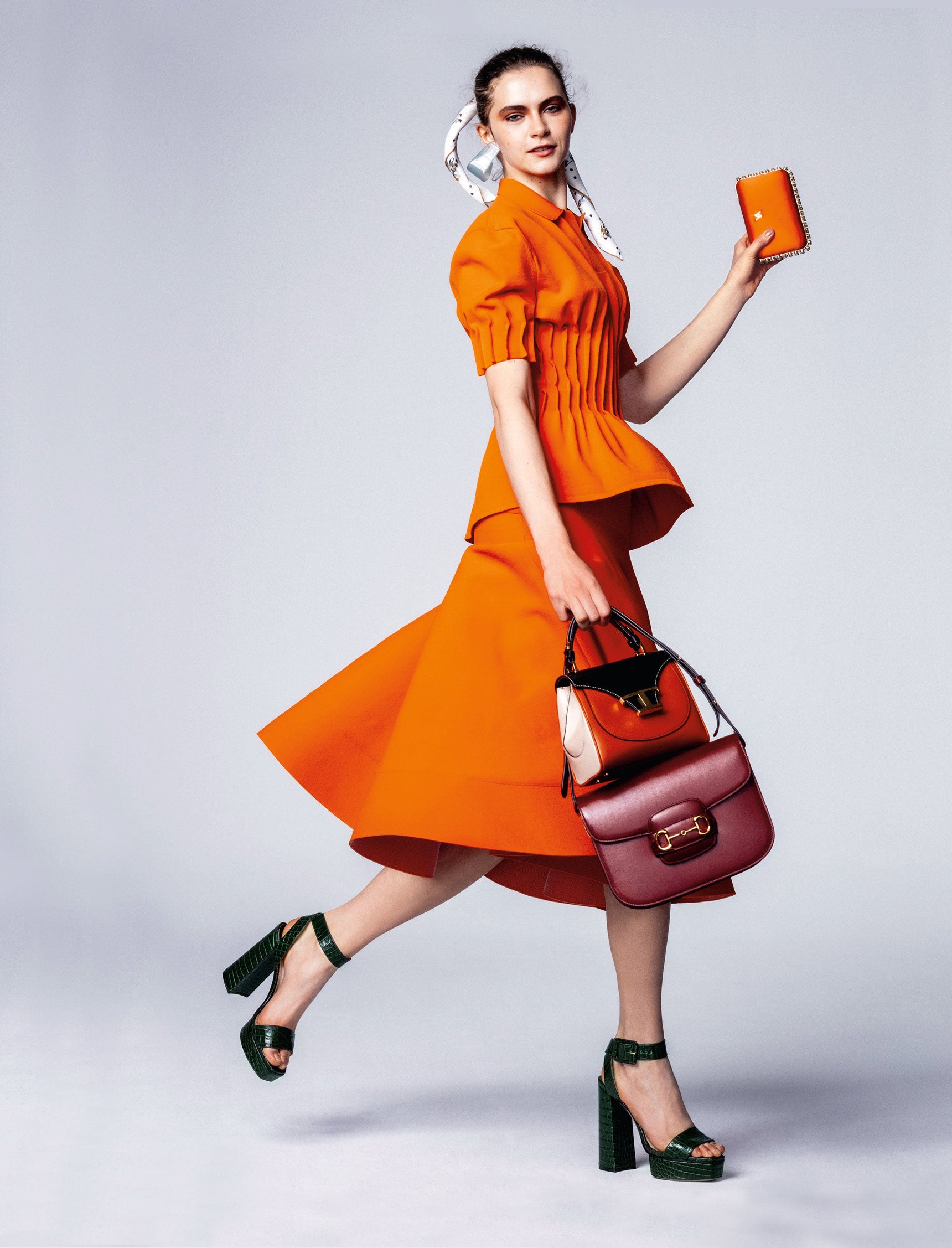 La camisa y la falda son de Nina Ricci. Bolso naranja, negro y blanco, de Tod’s bandolera Horsebit en cuero burdeos de Gucci y cartera de mano de Yliana Yepez. Sandalias de plataforma, de Jimmy Choo; pañuelo de Hermès; y pendiente de metacrilato, de Emporio Armani.