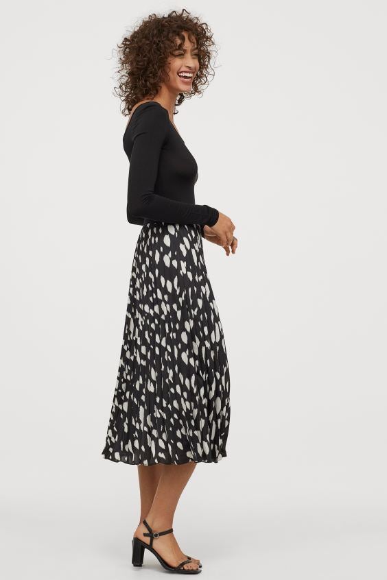 Falda midi satinada con cintura ajustada y estampado de manchas en tono blanco y negro. ¡Ultra favorecedora! (39,99 euros).