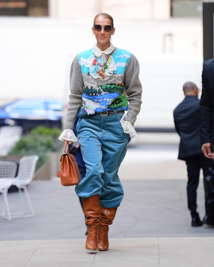 Céline Dion también se ha unido a la tendencia de llevar las botas por encima de los pantalones anchos, con un modelo marrón por encima de unos de pana. Sin embargo, el protagonismo del look se lo llevó un jersey bordado con un paisaje que combinó con una camisa con mangas y cuello de encaje.