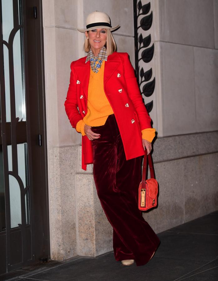De esta guisa, con un look firmado por Marc Jacobs de estilo masculino y muy colorido, salió Céline Dion de su concierto. Un estilismo formado por pantalón ancho granate, jersey de pico naranja, camisa y corbata de cuadros y abrigo de paño rojo. Además, añadió un bolso a juego y sombrero con el que no dejó a nadie indiferente.