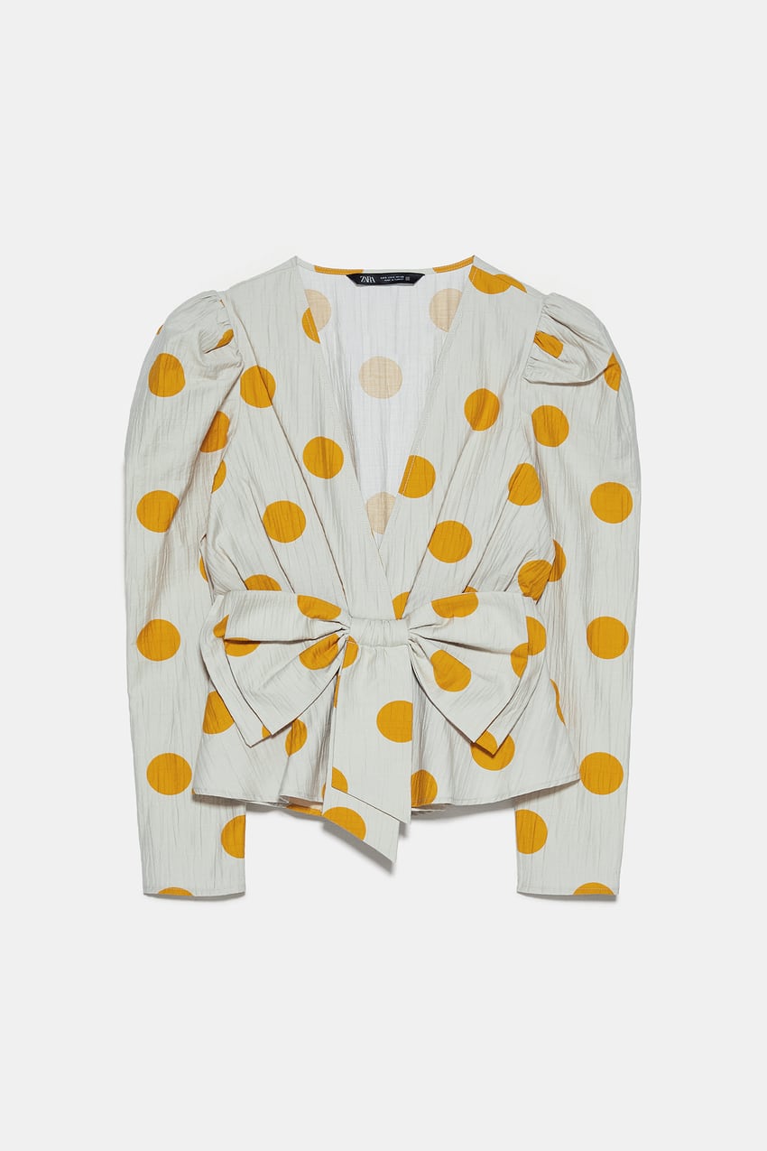 Blusa blanca con lazo y lunares en tono mostaza. (29,95 euros).